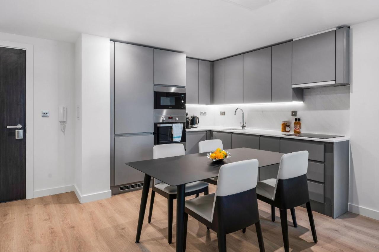 Citysuites 2 Aparthotel Manchester Exterior photo The photo shows a modern kitchen with a sleek and minimalist design. The cabinetry features a gray finish, and there are built-in appliances, including an oven and possibly a microwave. The countertop is light-colored, providing contrast to the darke